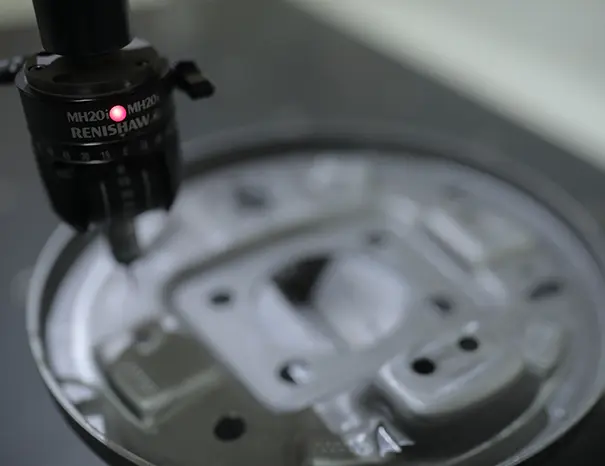Coordinate Measuring Machine verifying a pressed engine bracket against drawing tolerances