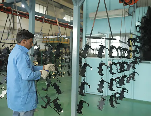 Conveyorized powder-coating line applying corrosion-resistant finish to chassis components
