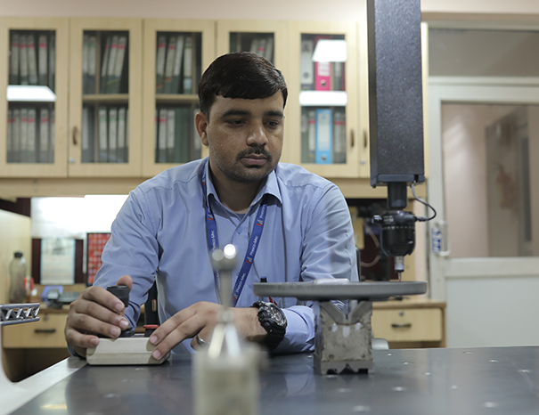 Coordinate Measuring Machine inspecting a stamped engine bracket for dimensional accuracy