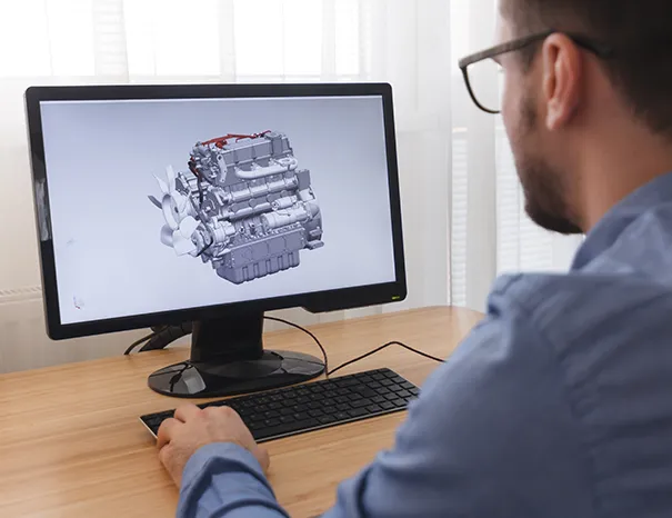 Engineer reviewing CAD tool design on screen for an automotive sheet-metal component