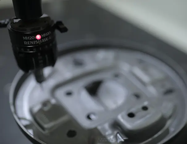 Engineer using a coordinate measuring machine to inspect an engine bracket