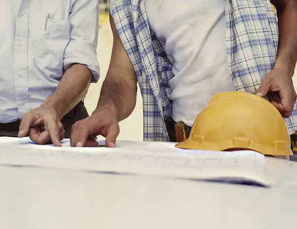 Engineers reviewing a component drawing during a manufacturability discussion