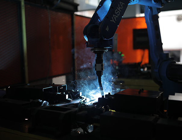 Robotic MIG welding cell joining a steel engine component sub-assembly
